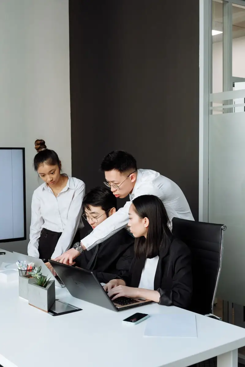 Business colleagues collaborating around a laptop